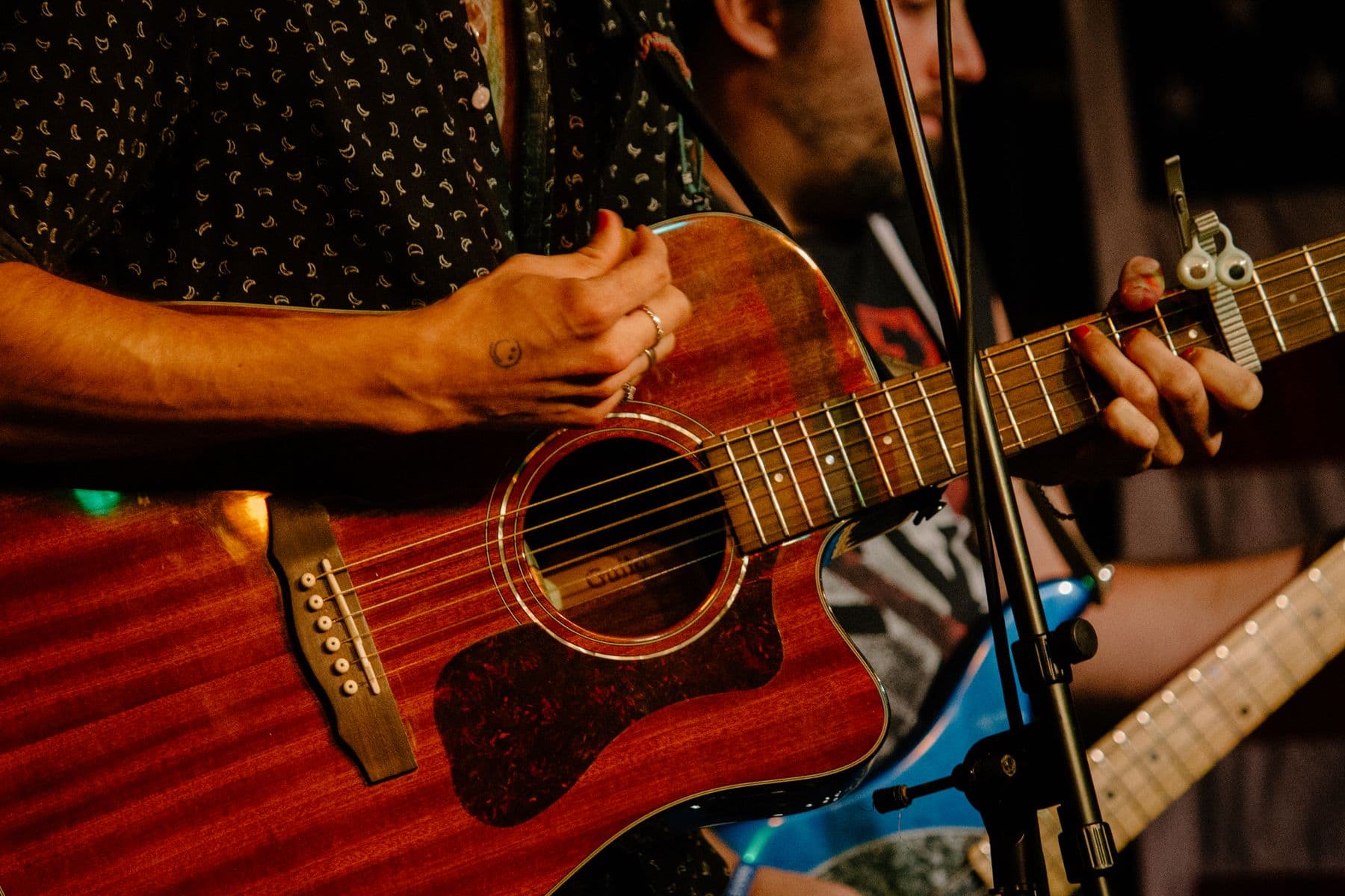 Hands playing an acoustic guitar at a live performance